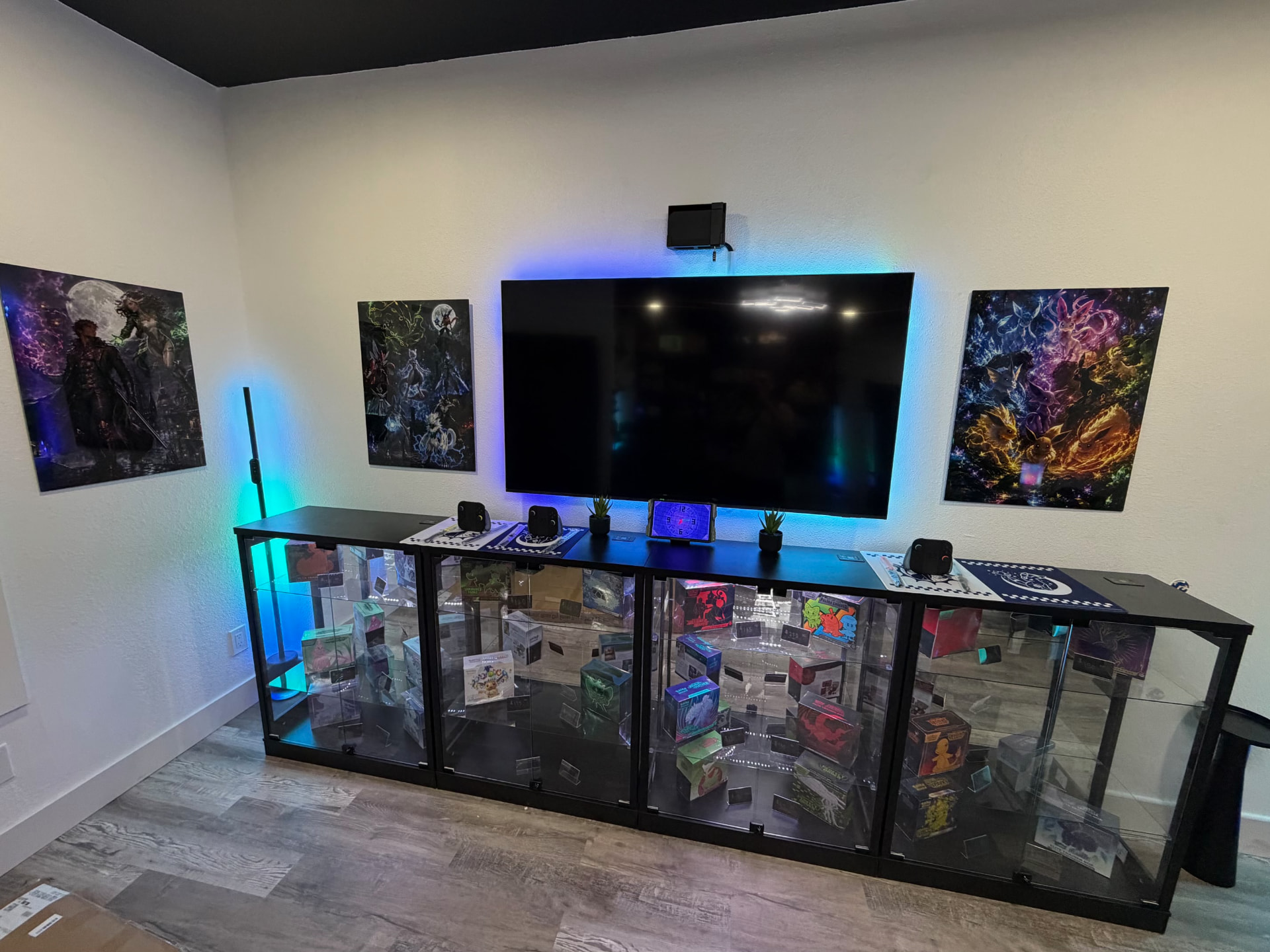Lit glass display cases of sealed boxes under wall art